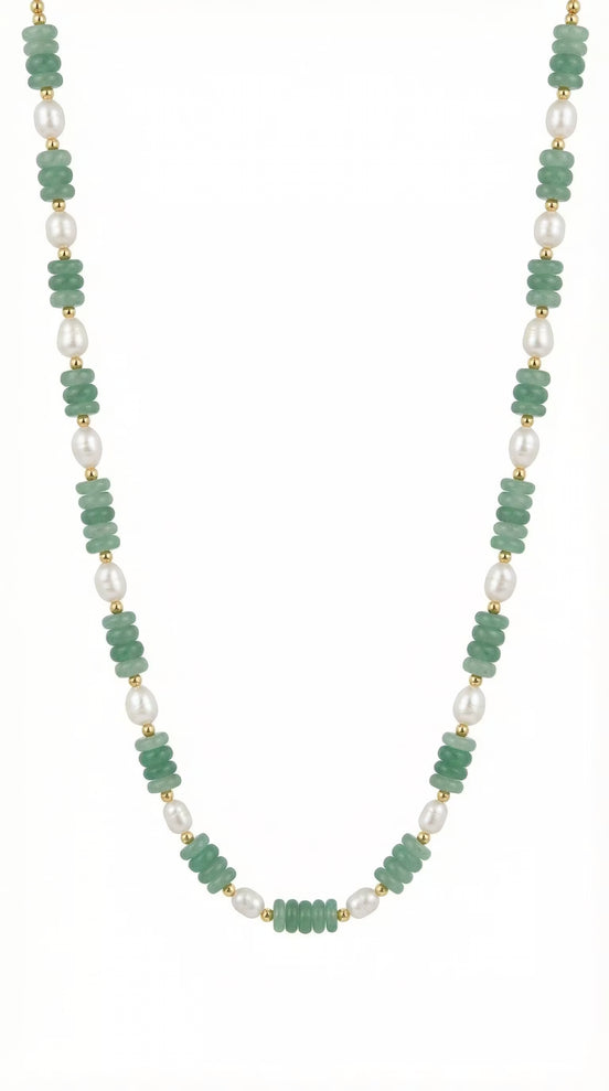 Colier desfășurat pe fundal alb compus din șirag subțire de pietre verzi și element central din perlă albă alungită cu închidere argintie.
