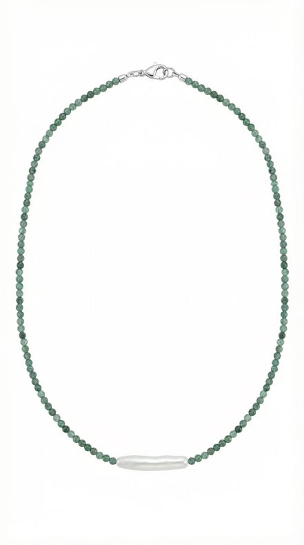 Colier desfășurat pe fundal alb compus din șirag subțire de pietre verzi și element central din perlă albă alungită cu închidere argintie.