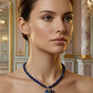 Femeie purtând un colier albastru la baza gâtului cu pandantiv mare dreptunghiular la o ținută cu umerii goi.