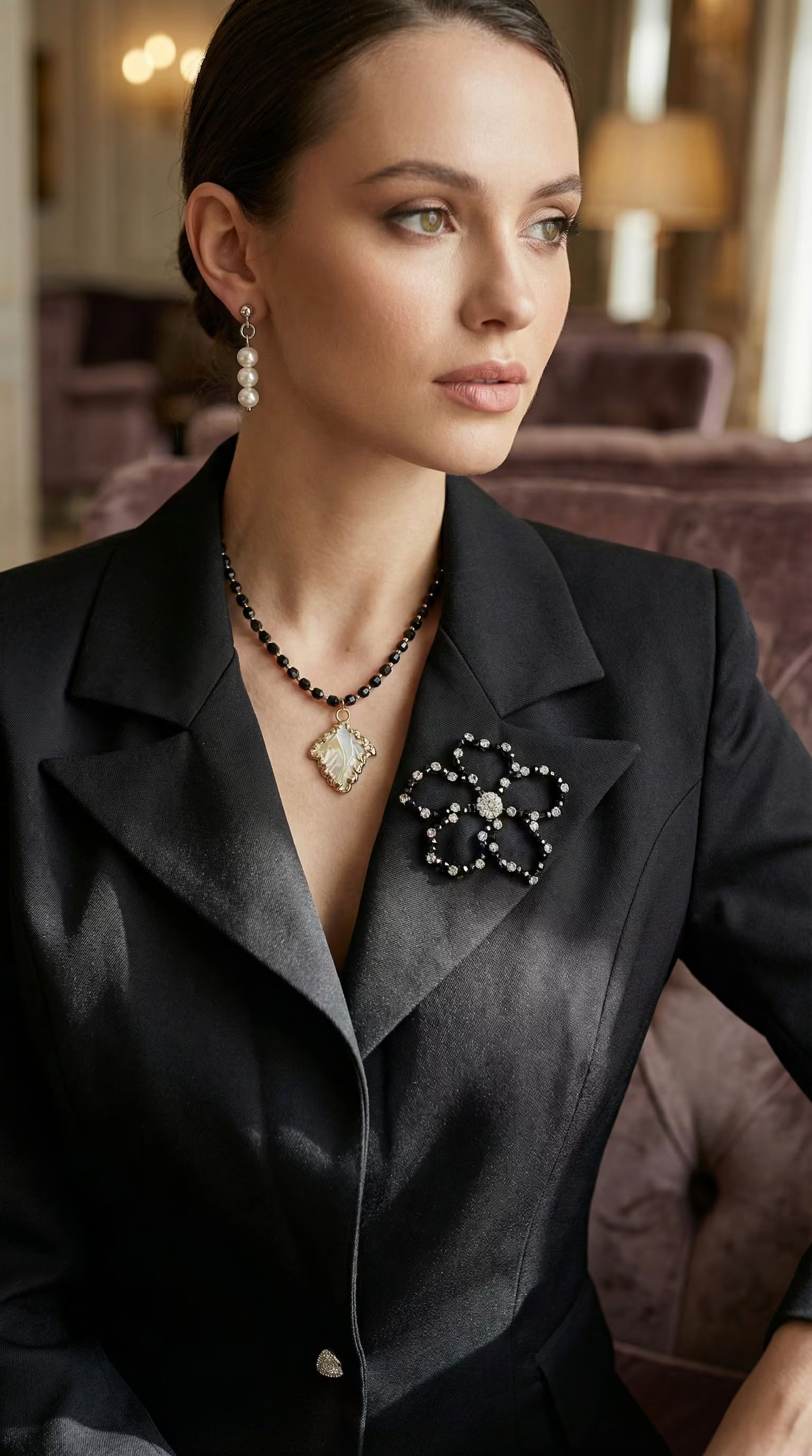 Vedere frontală detaliată a sacoului purtat evidențiind închiderea cu nasturi bijuterie triunghiulari și textura fină a materialului.