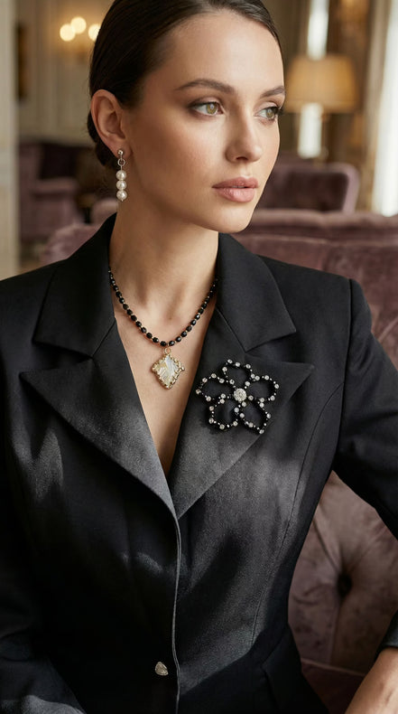 Vedere frontală detaliată a sacoului purtat evidențiind închiderea cu nasturi bijuterie triunghiulari și textura fină a materialului.