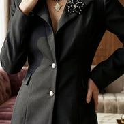 Femeie purtând un sacou negru elegant cu talie marcată și nasturi strălucitori asortat bijuterii create de Laura Stoica